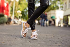 From the Gym to the Streets: How Sport Shoes Became Fashion Staples 5 Woman Rose Gold Sneakers Leather Pants